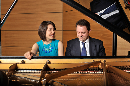 Stephanie Trick and Paolo Alerighi, pictured smiling and seated at a piano.