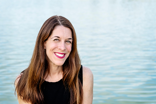 Catherine Pierce is wearing a black shirt with water behind her.