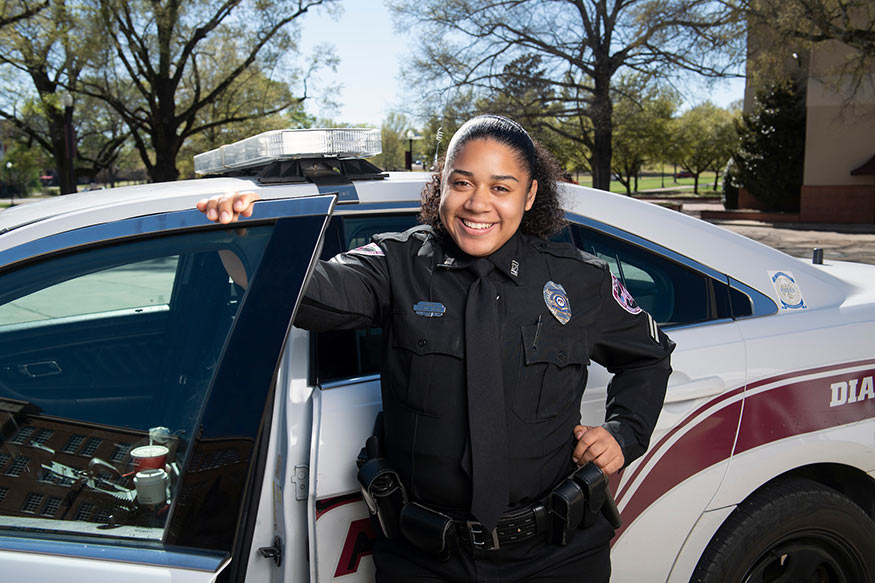 Corporal Chantel Solis-McCoy stands by an MSU Police car