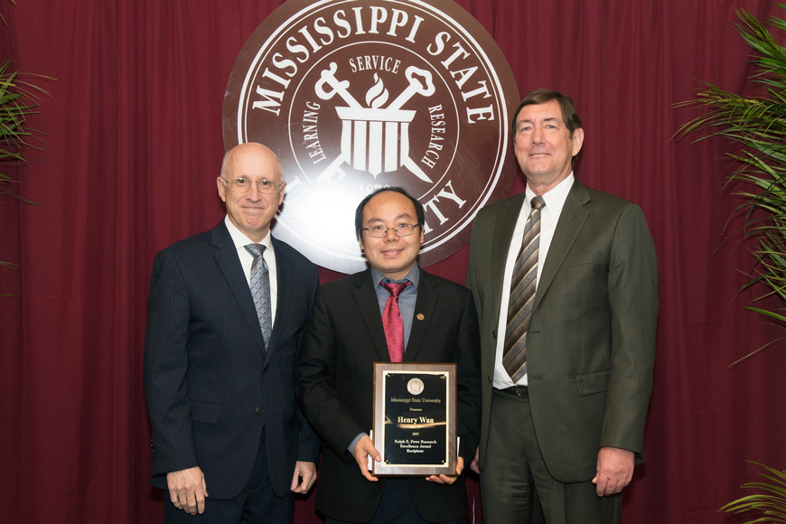 Dr. Henry Wan, center, honored with the 2017 Ralph E. Powe Research Excellence Award at Mississippi State, is congratulated by Vice President for Research and Economic Development David Shaw, left, and Vice President for the Division of Agriculture, Forestry and Veterinary Medicine Greg Bohach, right. (Photo by Beth Wynn)