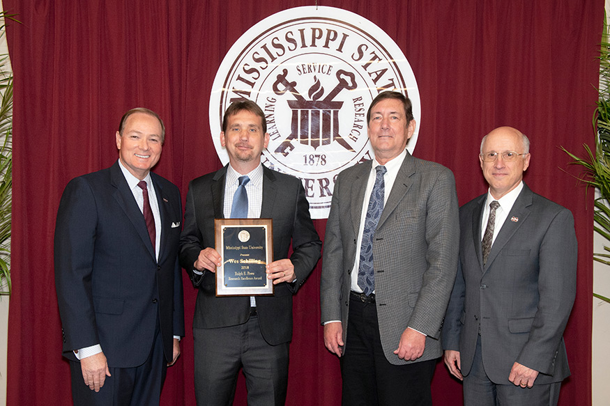 Mississippi State President Mark E. Keenum (l-r) congratulates 2018 Ralph E. Powe Research Excellence Award winner Wes Schilling, a professor of food science, nutrition and health promotion. Joining them at today's [April 16] annual research awards banquet for faculty, staff and students are Greg Bohach, the vice president for agriculture, forestry and veterinary medicine, and David Shaw, the vice president for research and economic development. (Photo by Beth Wynn)