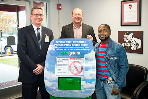 MSU’s Police Department received this medication dropbox safe today [Dec. 4] from the Mississippi Department of Mental Health. Shown with the dropbox, located in the department’s lobby, are, from left, Vance Rice, MSU Police chief; Michael Jordan of the MDMH, and Emmitt Johnson Jr., MSU Police corporal. (Photo by Russ Houston)