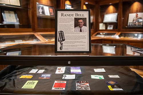 Display case of press passes from throughout Randy Bell’s 45-year career in radio news