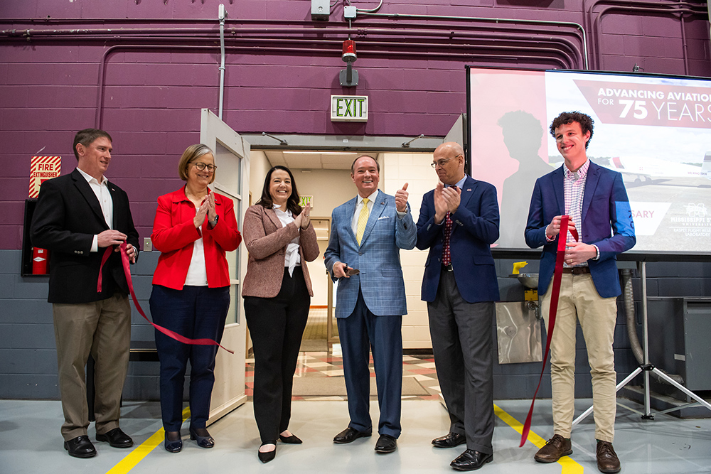 People smile after cutting a ribbon