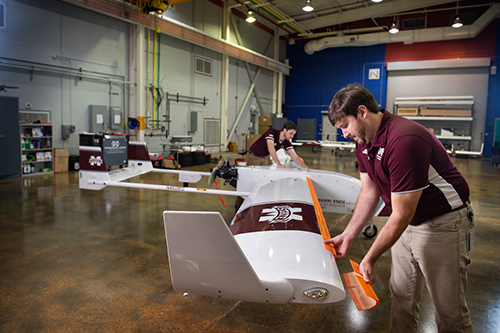 Raspet personnel adjust 3-D printed attachments on an unmanned aircraft system.