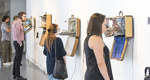 People browse the "UNPACKED: Refugee Baggage" multi-media exhibition