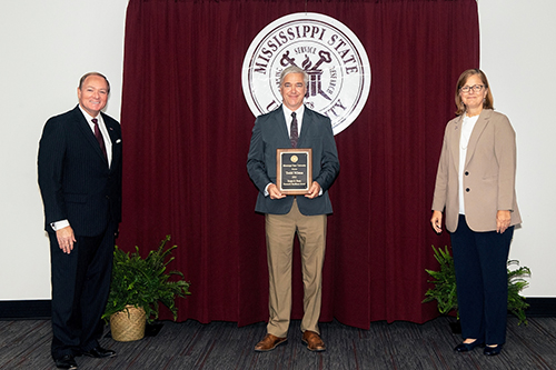 Mark Keenum, Todd Mlsna and Julie Jordan pose for an award after Mlsna is presented with the Powe Award