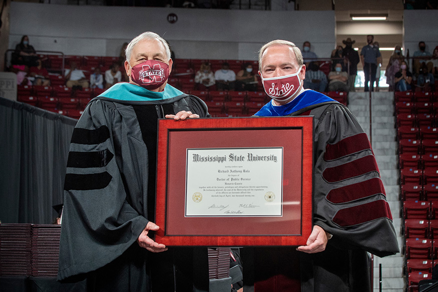 Mississippi State alumnus Richard A. Rula, left, and MSU President Mark E. Keenum hold a large framed diploma during MSU commencement ceremonies Friday [April 30]