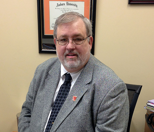 Portrait of Dana Chandler seated in his office