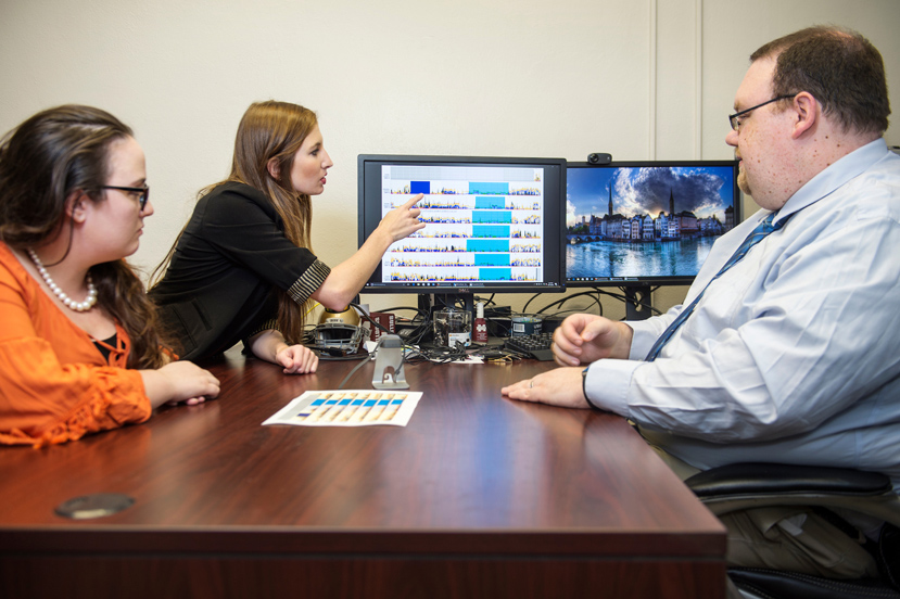 Under the guidance of Mississippi State Assistant Professor of Psychology Michael Nadorff, right, applied psychology/clinical psychology doctoral students Katrina “Kat” Speed of Columbus, left, and Brittany A. Kinman of Gulfport, center, analyze sleep patterns on a computer using a chart generated by an ActiGraph. Also known as an actimetry sensor, the watch-like device helps monitor human rest and activity cycles for one week when worn on the wrist of an individual experiencing sleep difficulties. (Photo by Megan Bean)