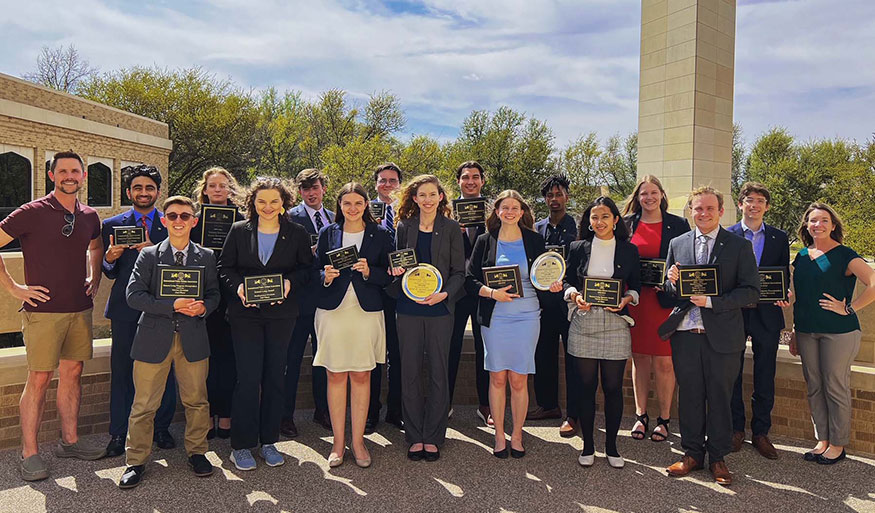 Speech and Debate Council members holding awards pose for a group photo