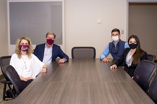 Kasee Stratton-Gadke, Steve Langton, Tyson Langston and Lorin Langston Chancellor sit at a conference table while wearing face masks.