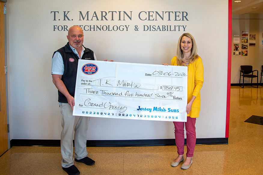 Jersey Mike's franchise owner Bret Dunnaway presents a donation check to T.K. Martin Center Director Kasee Stratton-Gadke.