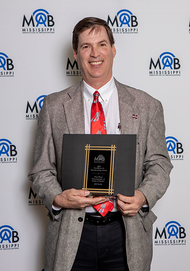 Terry Likes holding an award from the Mississippi Association of Broadcasters