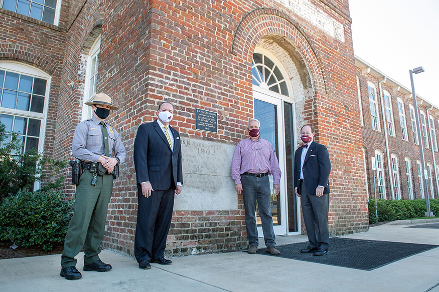 Unveiling one of two new plaques commemorating The Mill at MSU’s designation on the National Register of Historic Places are, from left, Officer Russell Branch of the National Park Service; MSU President Mark E. Keenum; Mark Castleberry of Castle Properties; and Deputy District Director Kyle Jordan of Congressman Michael Guest’s office.  