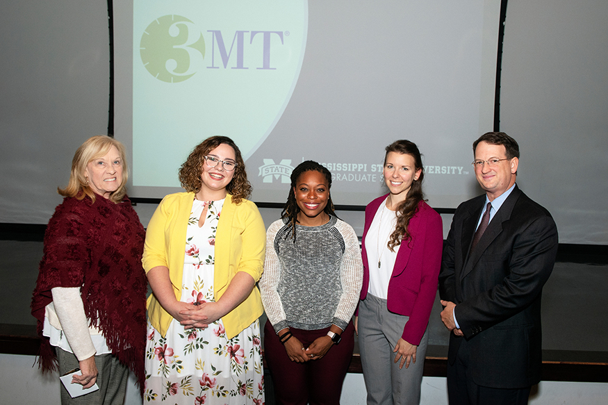Margaret McMullen and Brien Henry of MSU’s Graduate School stand with winners of the university’s annual Three Minute Thesis competition.