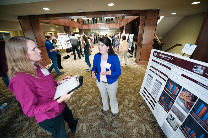 Mississippi State Summer Undergraduate Research Symposium participant Ashley L. Greene, a senior animal and dairy science major from Saint Johns, Florida, explains her research to Assistant Research Professor Kristine Evans of the university’s Geosystems Research Institute. (Photo by Megan Bean)