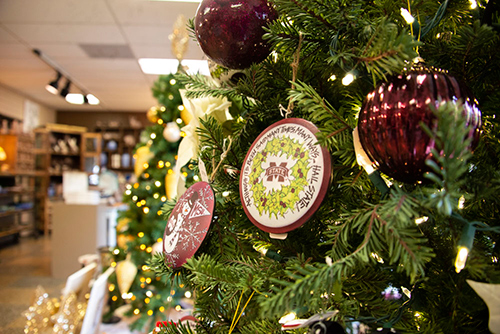 An up-close shot of a Christmas tree decorated with MSU ornaments and a section of the University Florist shown in the background.
