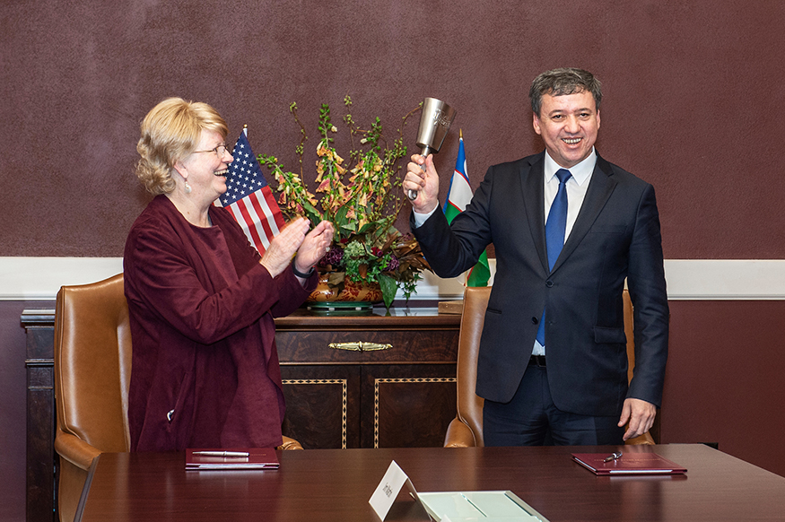 MSU Provost and Executive Vice President Judy Bonner presents a cowbell to Botirjon Sulaymonov, rector of Uzbekistan’s Tashkent State Agrarian University, after signing a memorandum of understanding to encourage research and academic partnerships between the two universities. (Photo by Megan Bean)
