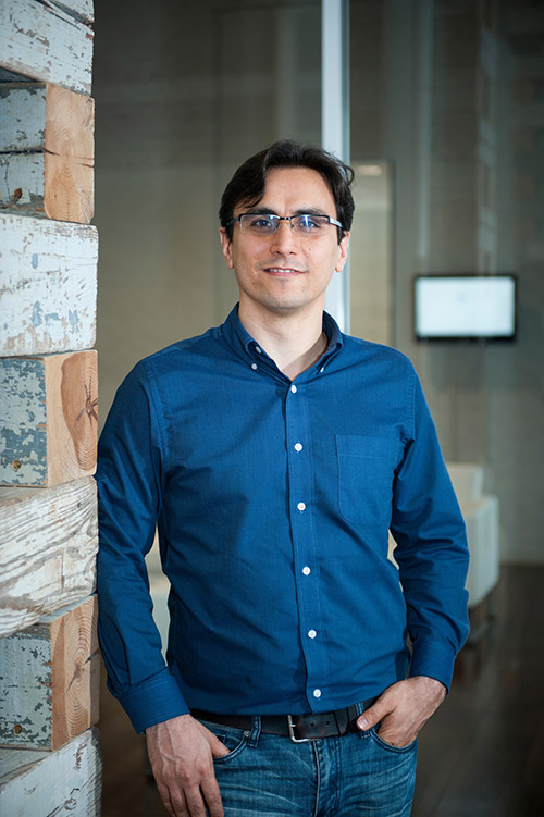 Farshid Vahedifard standing next to a wooden wall