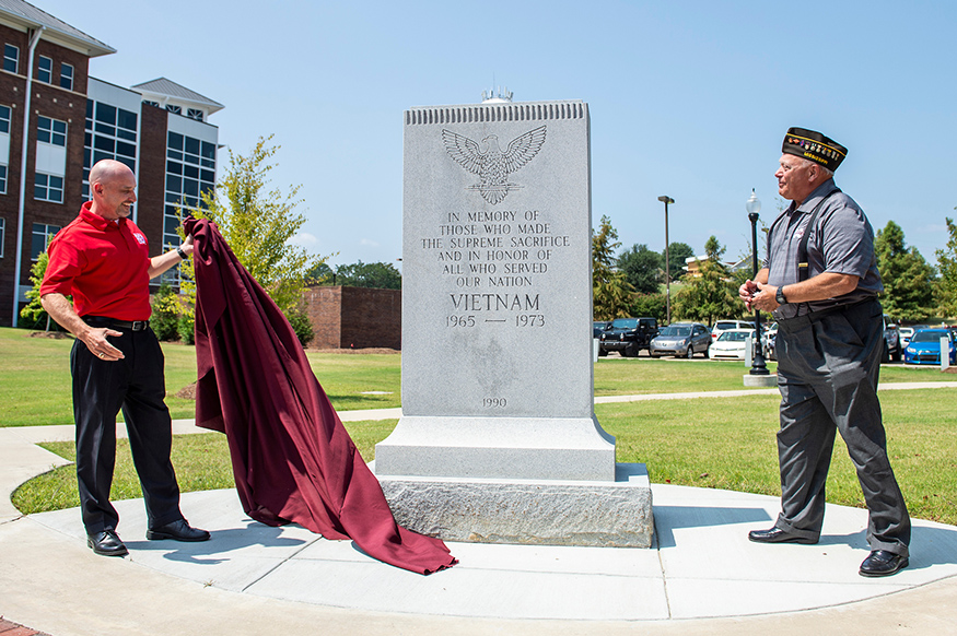 Lt. Col. (Ret.) Brian Locke, director of Mississippi State’s G.V. “Sonny” Montgomery Center for America’s Veterans, and Vietnam War veteran Bob Kirkland unveil MSU’s Vietnam War memorial in its new location outside of Nusz Hall. (Photo by Logan Kirkland)