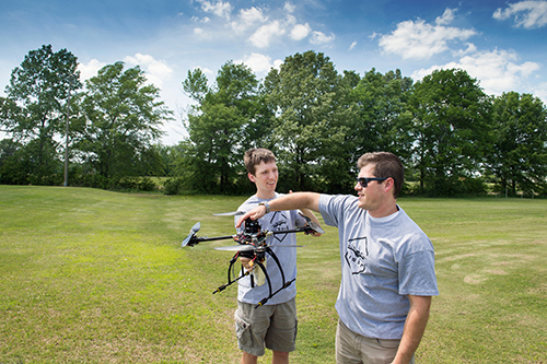 Logan Smith, left, a graduating senior computer engineering major from Petal, and Joseph Cuty, a graduating senior electrical engineering major from Diamondhead, adjust one of WISPr Systems’ unmanned aircraft vehicles. The two have worked for the start-up company while completing coursework in MSU’s Bagley College of Engineering. (Photo by Megan Bean)
