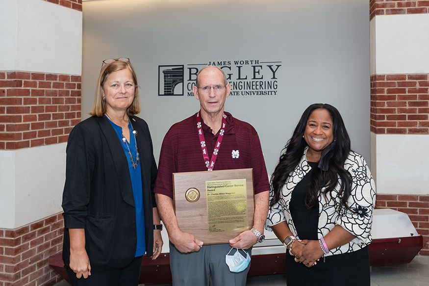 Julie Jordan and Nicole Nelson-Jean present Charlie Waggoner with a Department of Energy distinguished service award.