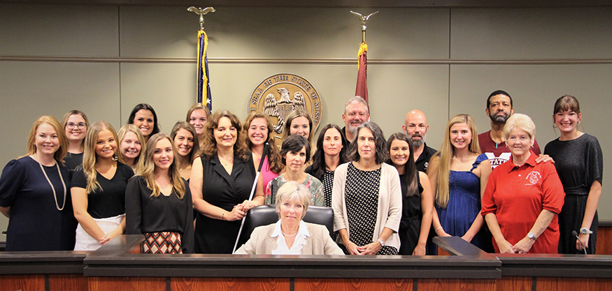 Starkville Mayor Lynn Spruill, center, signs a proclamation to designate Oct. 15 as White Cane Awareness Day. Looking on were representatives from MSU’s National Research and Training Center on Blindness and Low Vision, Delta Gamma sorority, MSU Disability Support Services and local community members. 