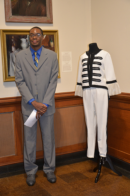 MSU senior art/fine arts major Dionicio D. “Dion” Coleman of Rex, Georgia, presents his research at the Lauren Rogers Museum of Art in Laurel while standing next to an original fashion design by Gabrielle Martinez, an MSU senior fashion design and merchandising/design and product development major from Byhalia. Martinez’s design was inspired by Benjamin West’s oil painting “J. Fall,” c. 1765–1770. (Submitted photo/courtesy of Phyllis Bell Miller)