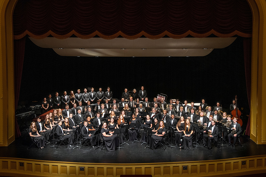 Members of MSU’s Wind Ensemble smile for a group photo on the Bettersworth Auditorium stage.