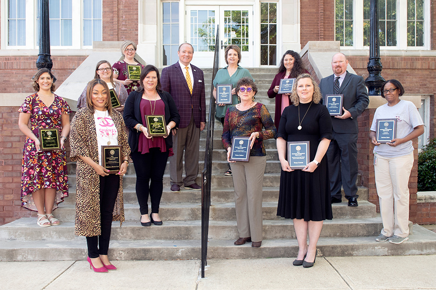 MSU President Mark E. Keenum and this year’s Donald W. Zacharias Distinguished Staff Award recipients stand on the front steps of Lee Hall.