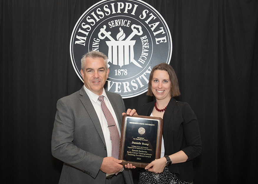 Associate Vice President Jim Dunne presents the Donald Zacharias Early Career Outstanding Undergraduate Teaching Excellence Award to Danielle Young. 