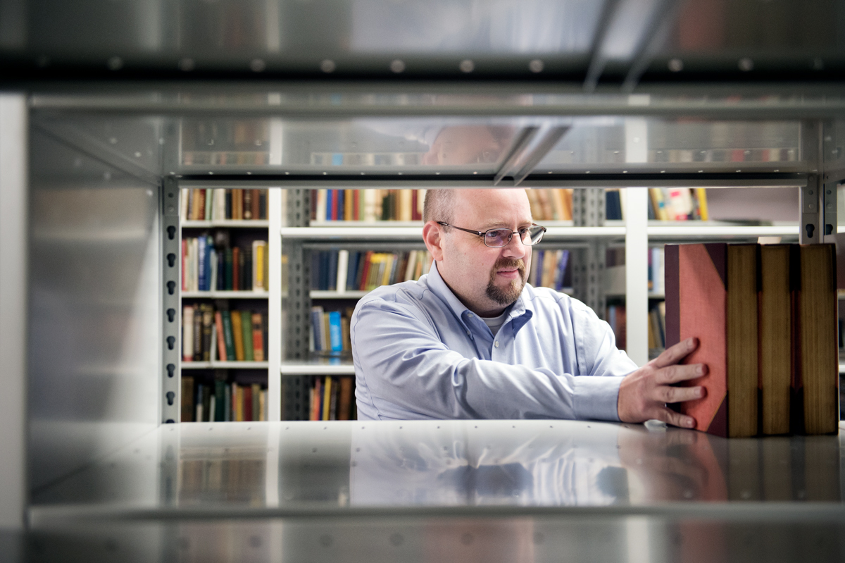 Ryan Semmes, pictured in-between a row of books at MSU's Mitchell Memorial Library.