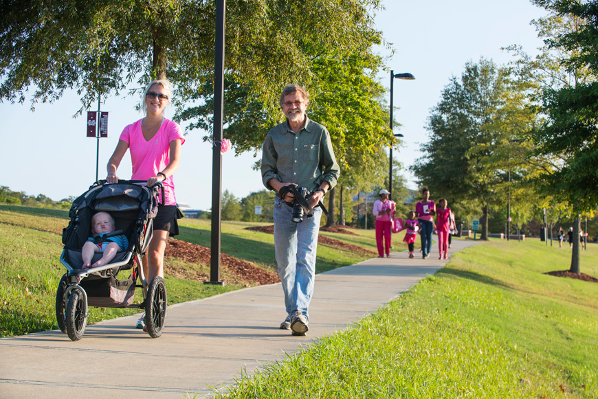 Jordan Ramsey walks the 2014 Pink Dawg Walk with her father, Lynn Reinschmidt, and her son, Ryan. The family participates to promote awareness and preventative measures, as well as in memory of Judy Reinschmidt, who passed away in 2003 from breast cancer.