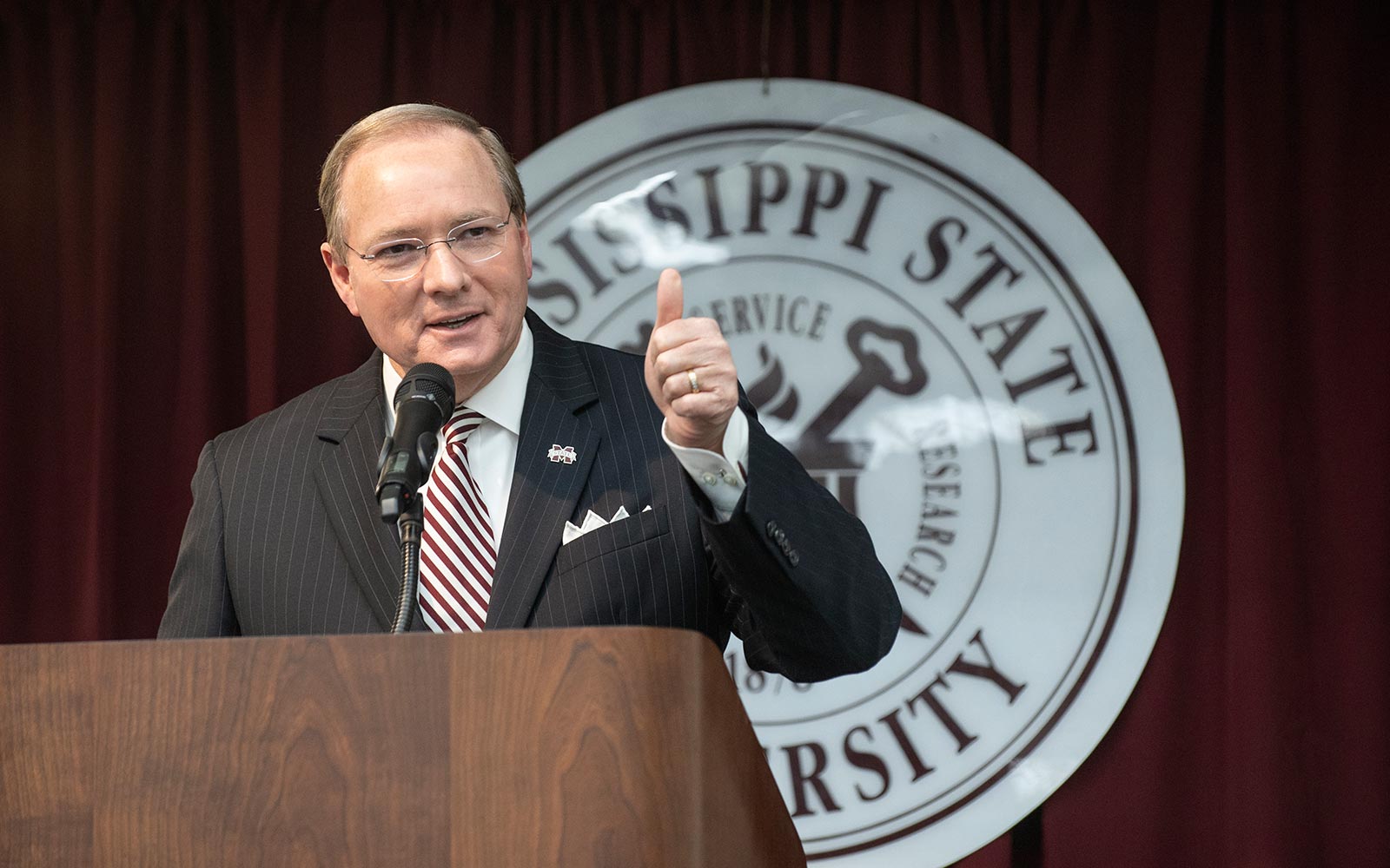 MSU President Mark. E. Keenum speaking at a podium in front of the MSU seal.