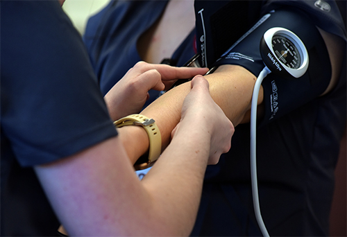 a close-up shot of someone taking a patient's blood pressure