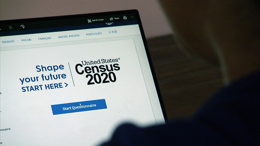 A close-up of the census website as a person looks at a laptop