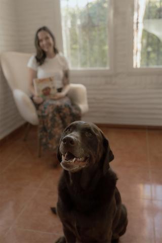 Portrait of Holly Trisch's dog with her in the background