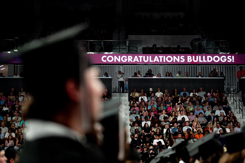 A banner reading &quot;Congratulations, Bulldogs!&quot; is displayed during commencement at Humphrey Coliseum.