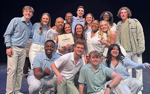 Members of Mississippi State's Trebulldawgs pose on stage.