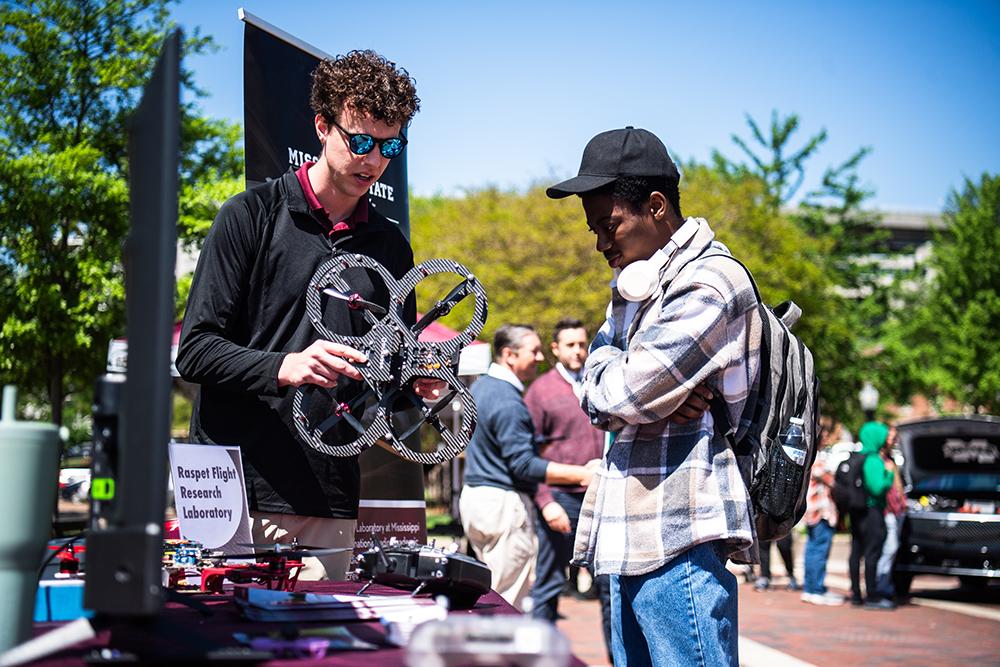 Brady Swan, research engineer with MSU’s Raspet Flight Research Lab, shows an MSU student one of the many drones the research center uses as part of its work to advance uncrewed aviation.