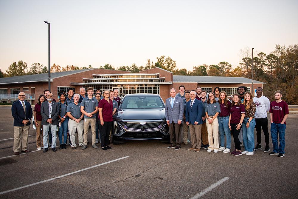 The MSU EcoCAR team poses around a car with advisors, professors and university administrators.