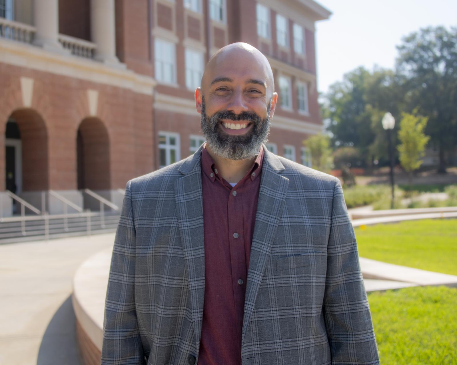 man in maroon shirt and blazer outside