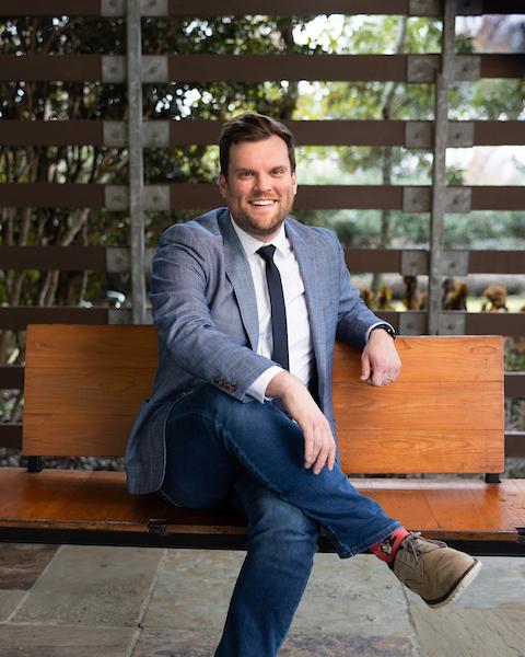 man in suit on wood bench