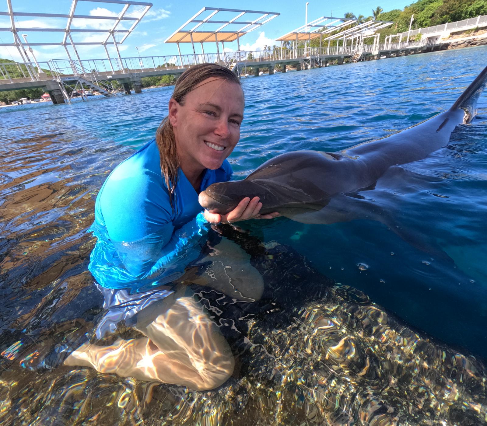 woman in water with dolphin
