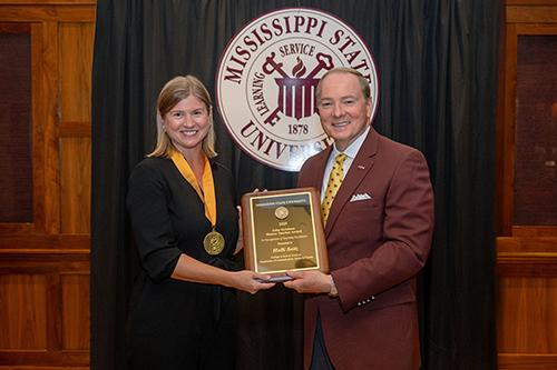 Mississippi State President Mark E. Keenum presents Associate Professor Holly Seitz, left, with the Grisham Master Teacher Award, the university’s highest honor for teacher excellence, in August.