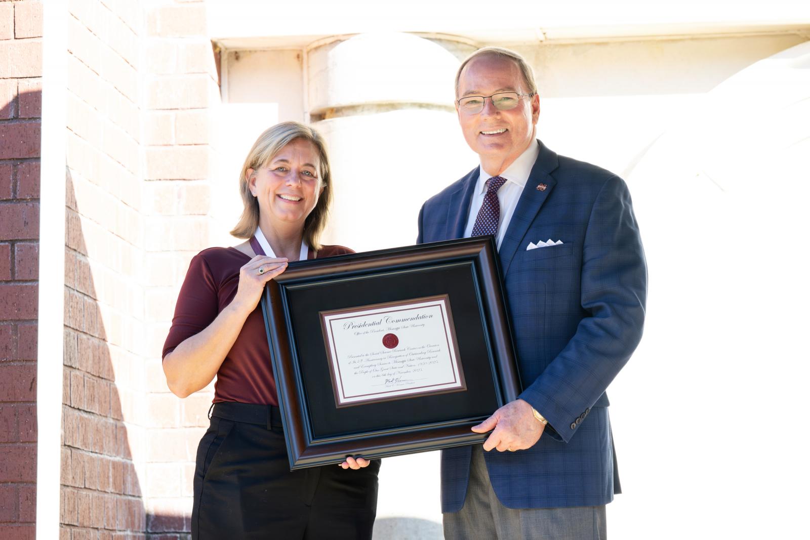 man and woman stand with certificate