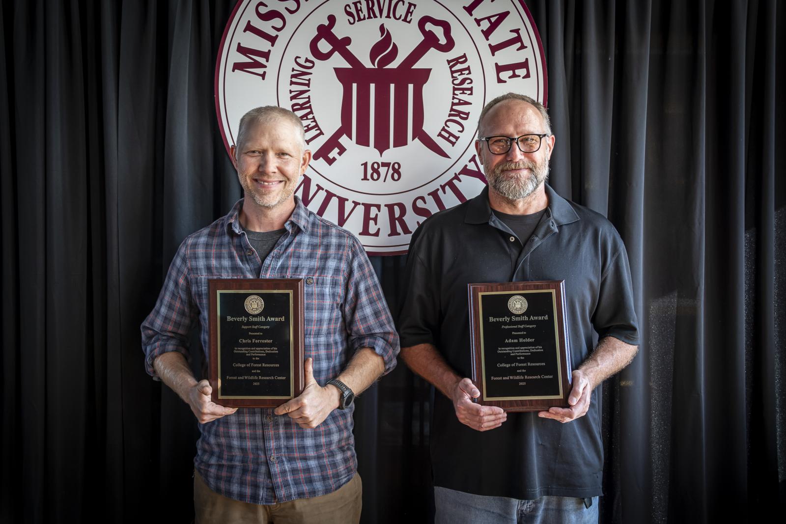two men holding the university awards