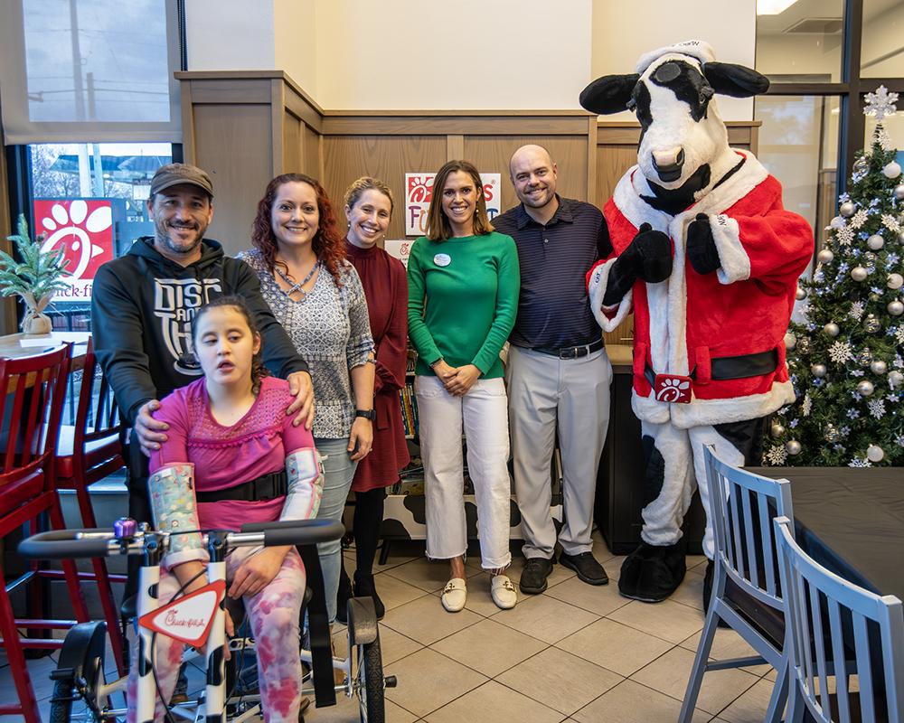 Pictured behind Alyssa Greer, from left, are parents Jonathan and Brittany Greer, the university’s Mississippi Institute on Disabilities Executive Director Kasee Stratton-Gadke, Starkville Chick-fil-A Community Connections Director Melissa Rogers, Chick-fil-A owner and operator Jonathan Rogers and the restaurant's mascot.