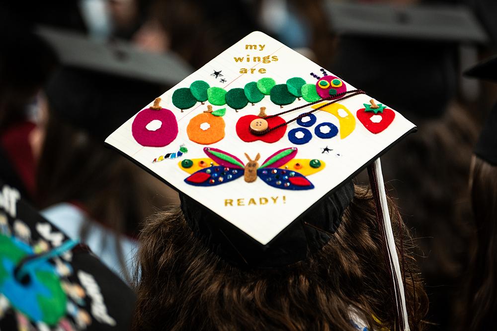 A student displays a cheerful message on their mortarboard.